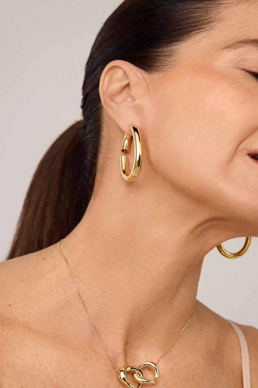 Gold hoop earring with smooth curves and a polished finish.