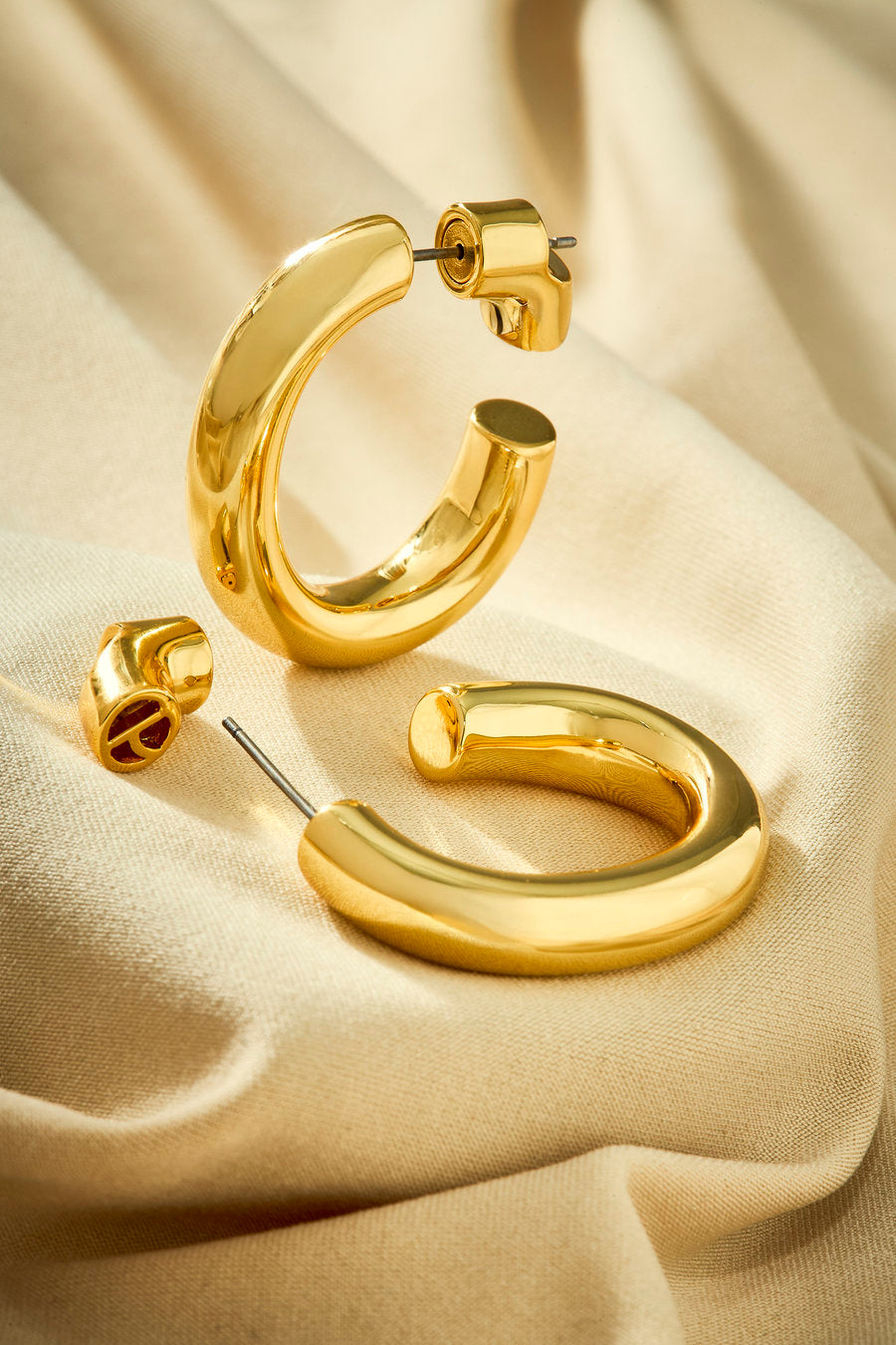 Small gold hoop earring with a fluid and contemporary design.
