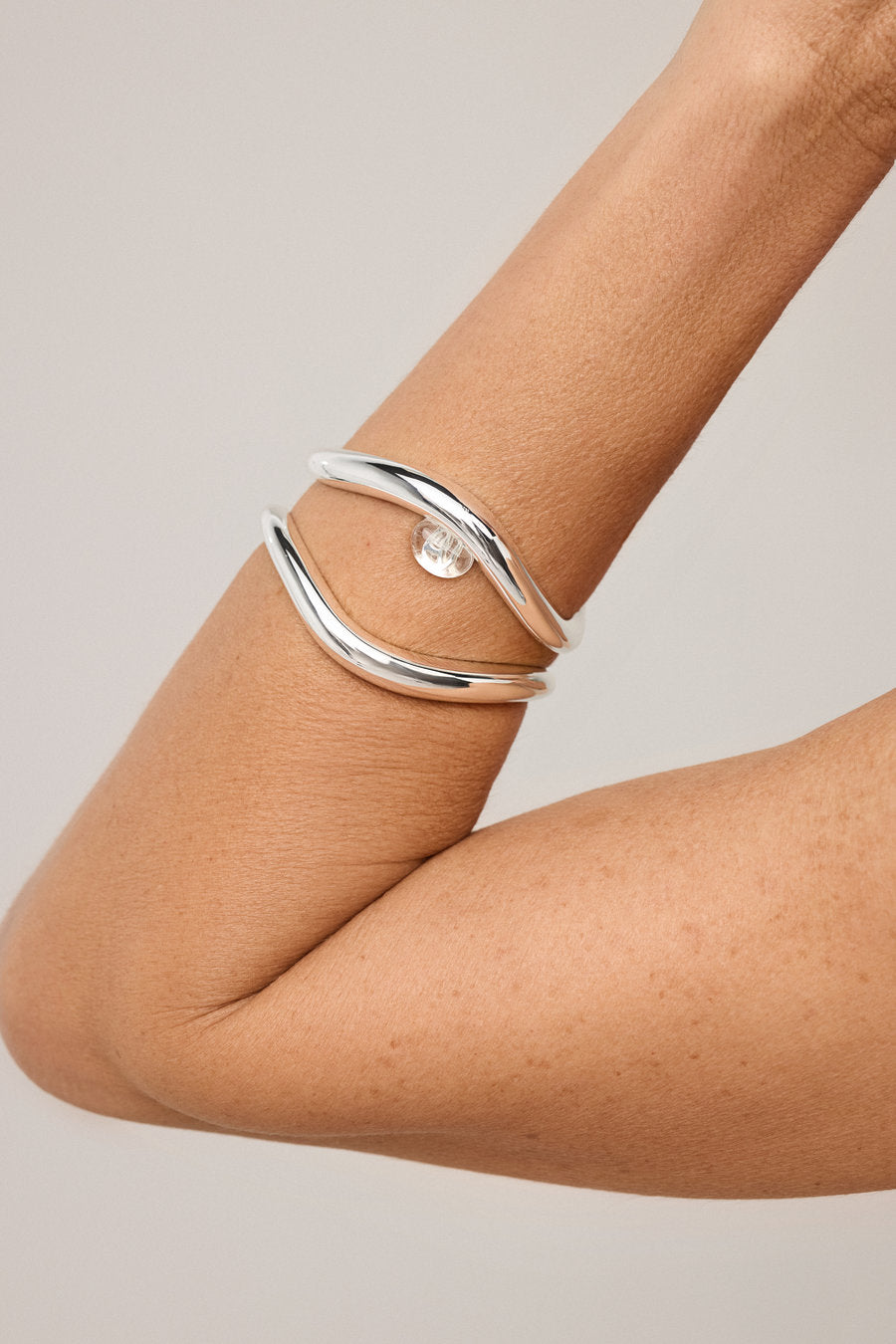 Women's silver bracelet with clear crystal and organic shape.
