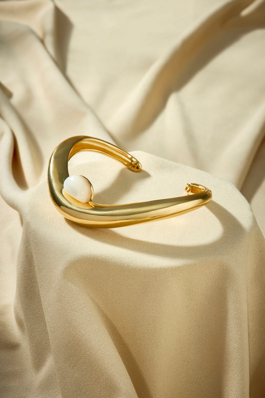 Women's gold bracelet with mother-of-pearl and elegant organic shape.