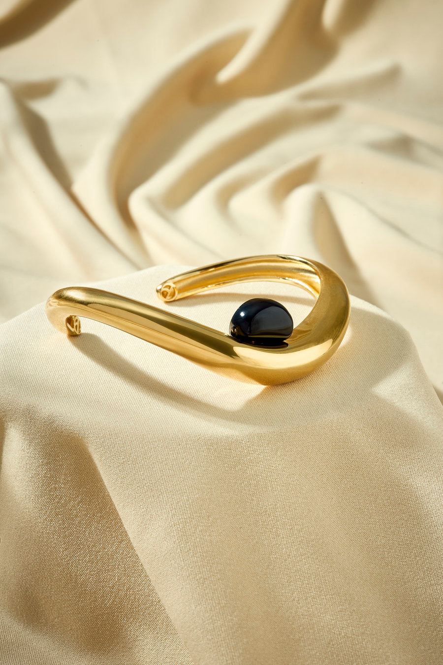 Gift bracelet with onyx in gold-tone metal and contemporary design.