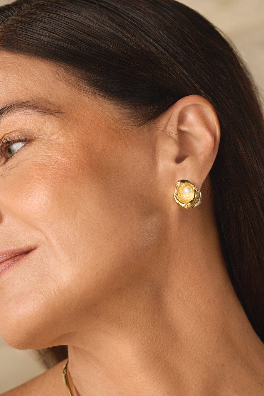 Two-tone found earring with a central pearl and organic sculptural design.