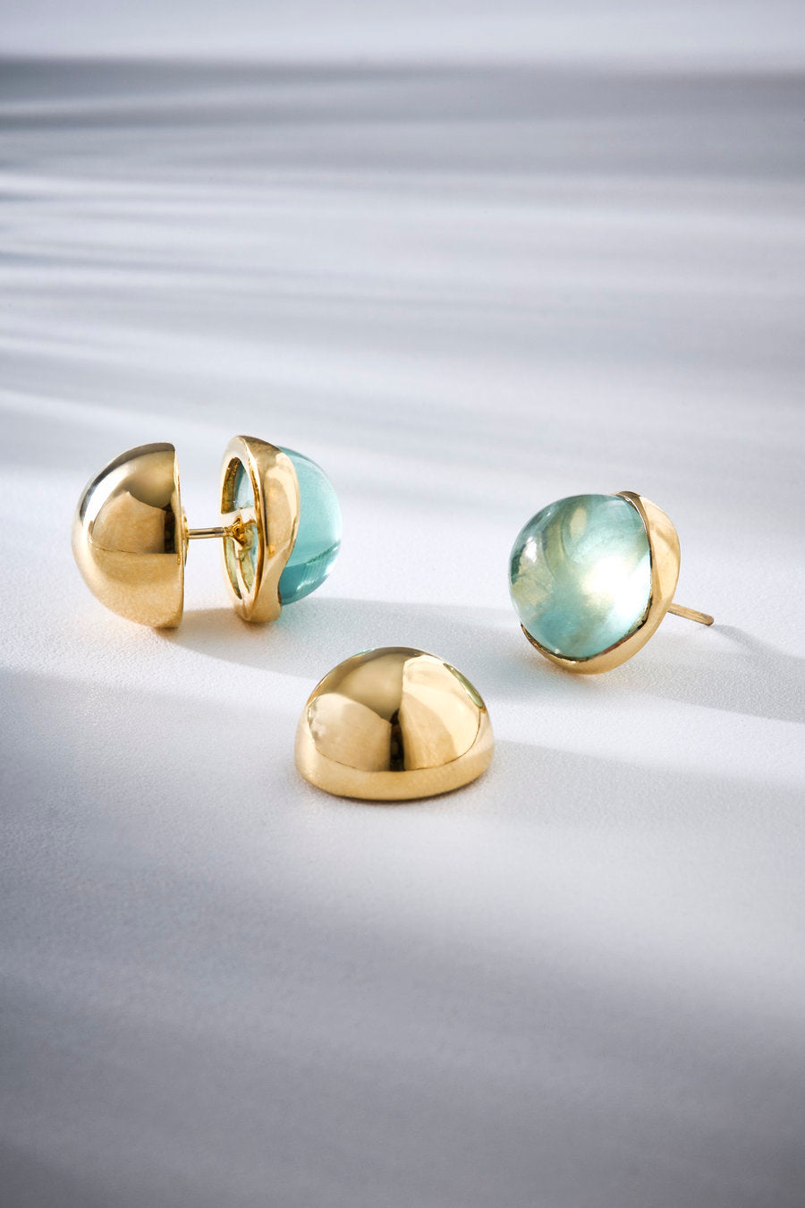 Gold-toned Green Duo earrings with a contemporary design and translucent green stone, ideal for elegant and sophisticated looks.