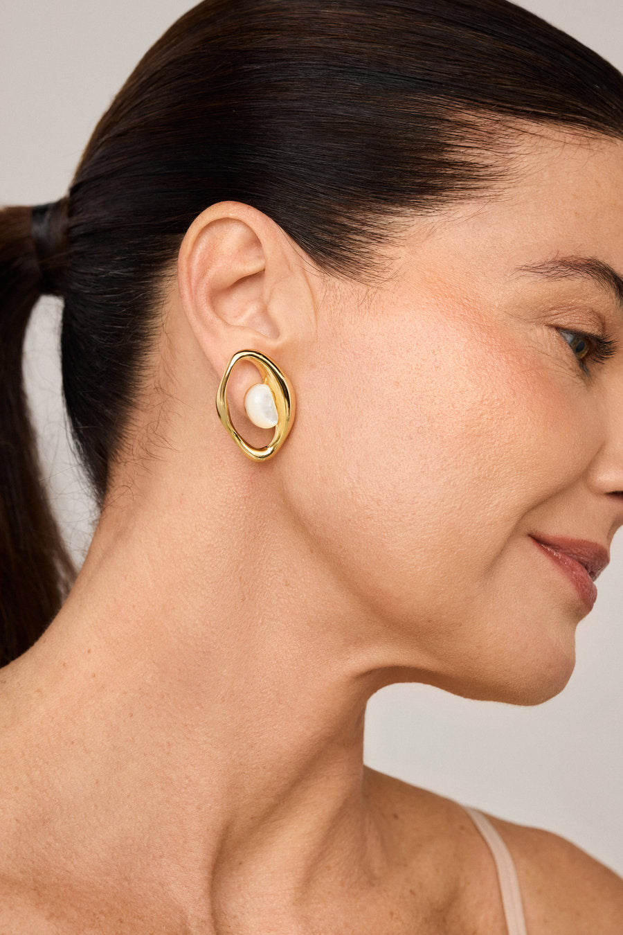 Gold-plated gift earring with mother-of-pearl and organic sculptural design.