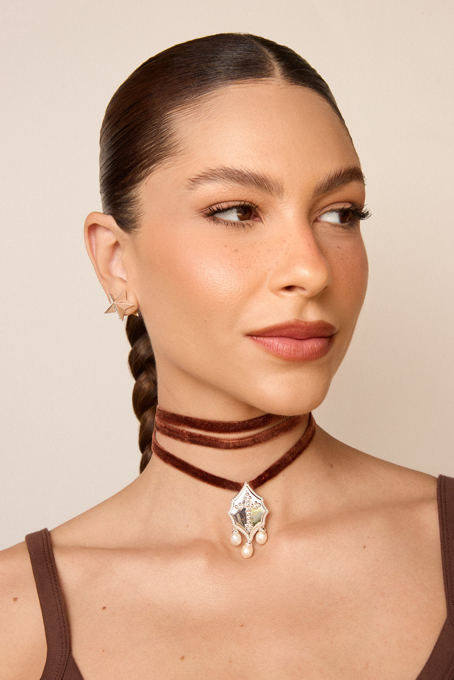 Gold Authority choker with black velvet ribbon, ornamental pendant and pearls, used in women's fashion styling.