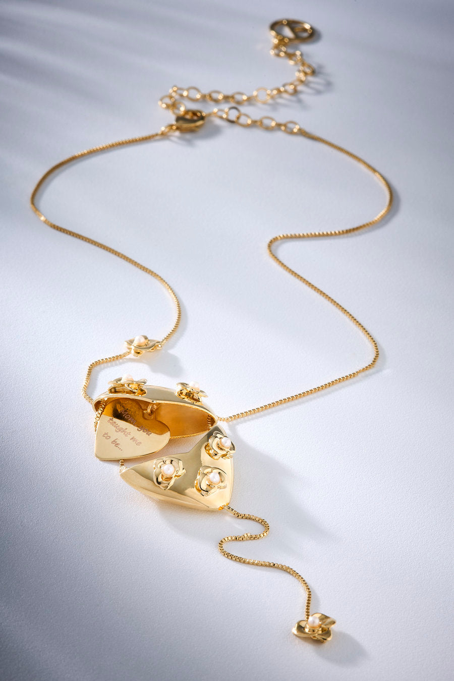 necklace inspired by bonds built over time, featuring a heart locket, delicate flowers, and an internal message that symbolizes the memory of maternal love.