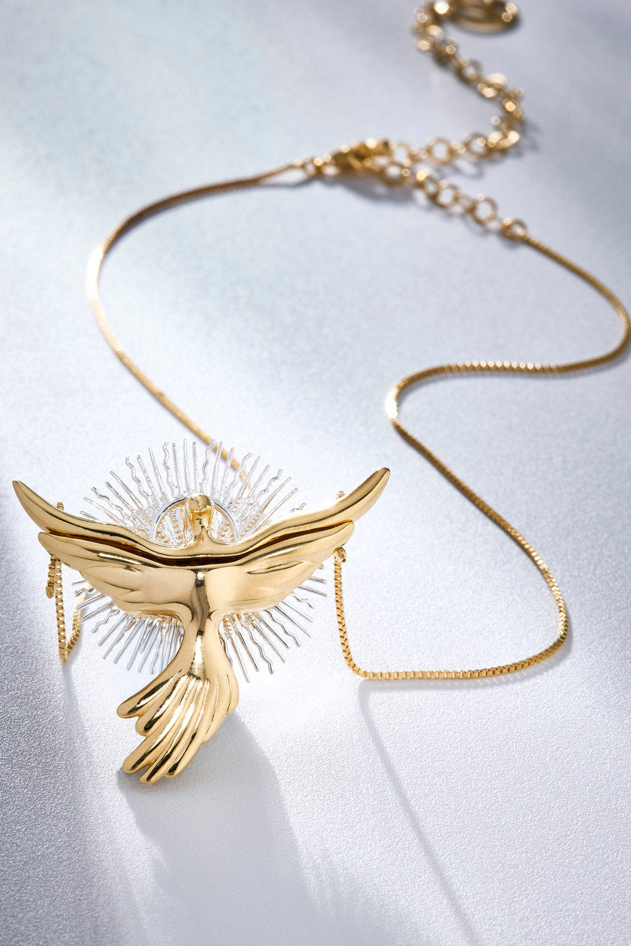 Promise necklace inspired by the presence of the Holy Spirit, featuring a gold dove and a luminous composition that symbolizes constant protection and invisible care.