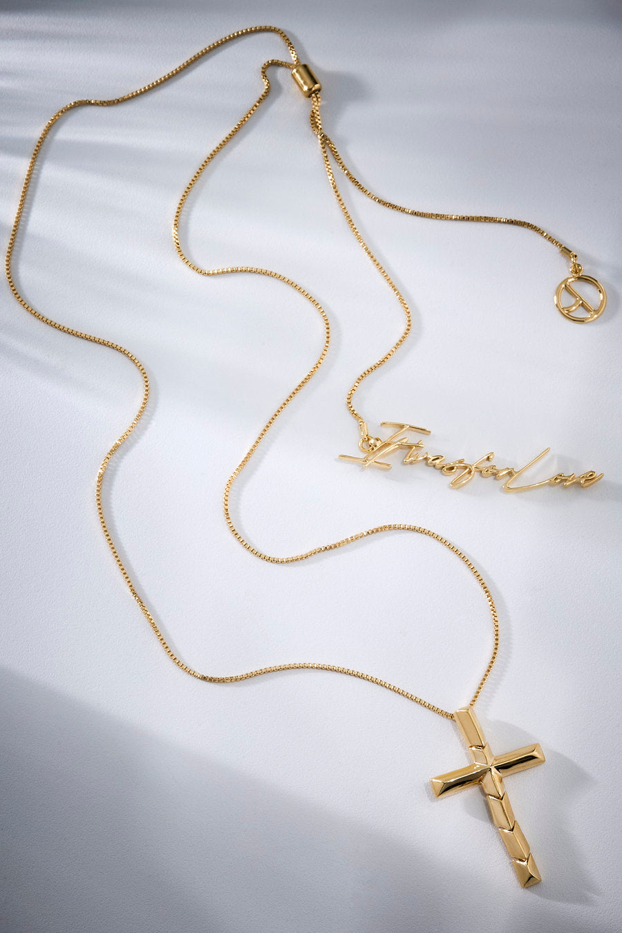 Gold-toned Redemption necklace featuring a sculptural cross that symbolizes absolute love, devotion, and the deep bond between faith, sacrifice, and maternal devotion.