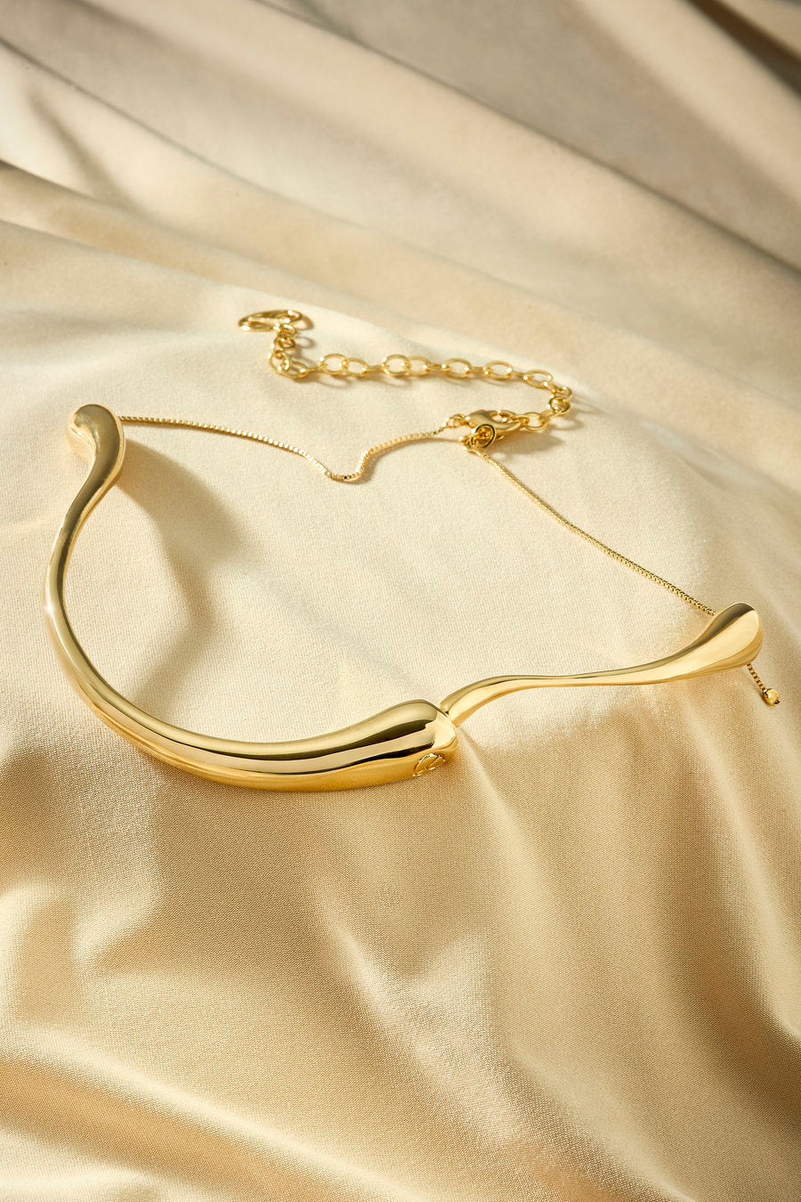 Gold choker with curved lines and a contemporary minimalist look.