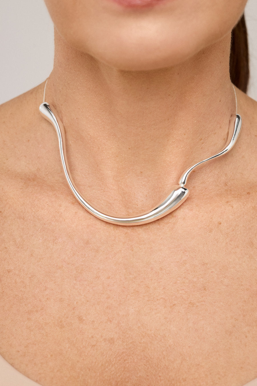 Gold choker necklace with an organic shape and polished finish.