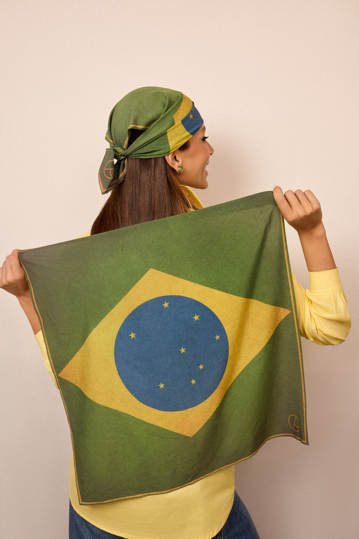 Woman wearing a green Brazil-inspired scarf styled on the head for a festive look.