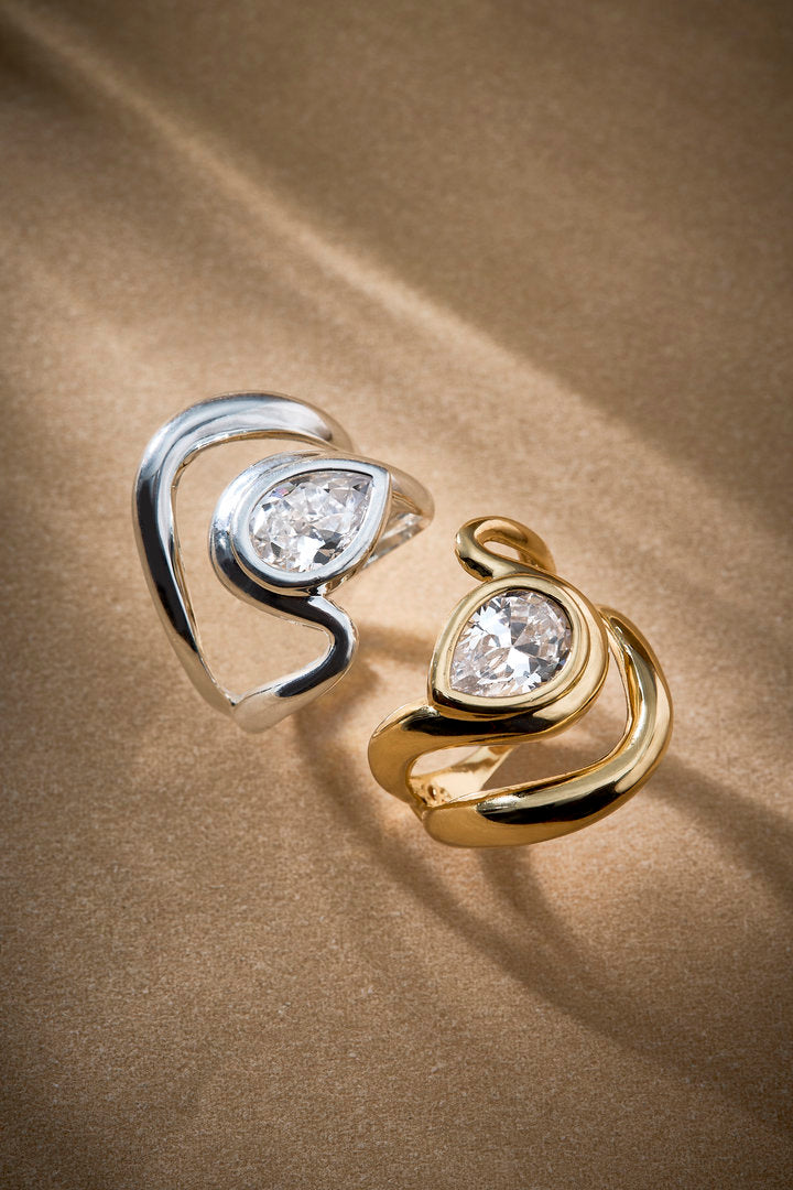 Audrey adjustable ring in gold and silver tones, featuring soft curves and a central crystal. A delicate, contemporary piece that embodies charm, elegance, and refinement.