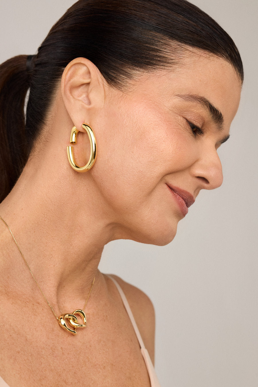 Women's gold hoop earring with an organic and elegant design.
