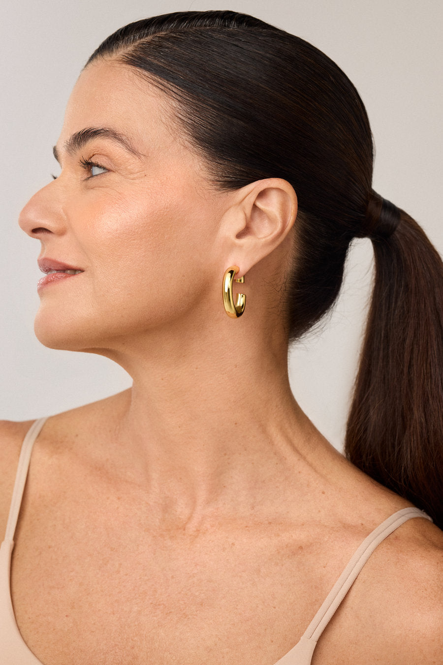 Small gold hoop earring with soft lines and a minimalist look.
