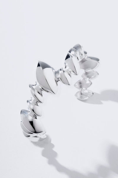 The Trama Bracelet translates the lightness of nature into a piece of botanical-inspired jewelry. Featuring stylized, flowing leaves, a polished finish, and a sculptural presence, it embraces the arm with radiance, harmony, and sophistication.
