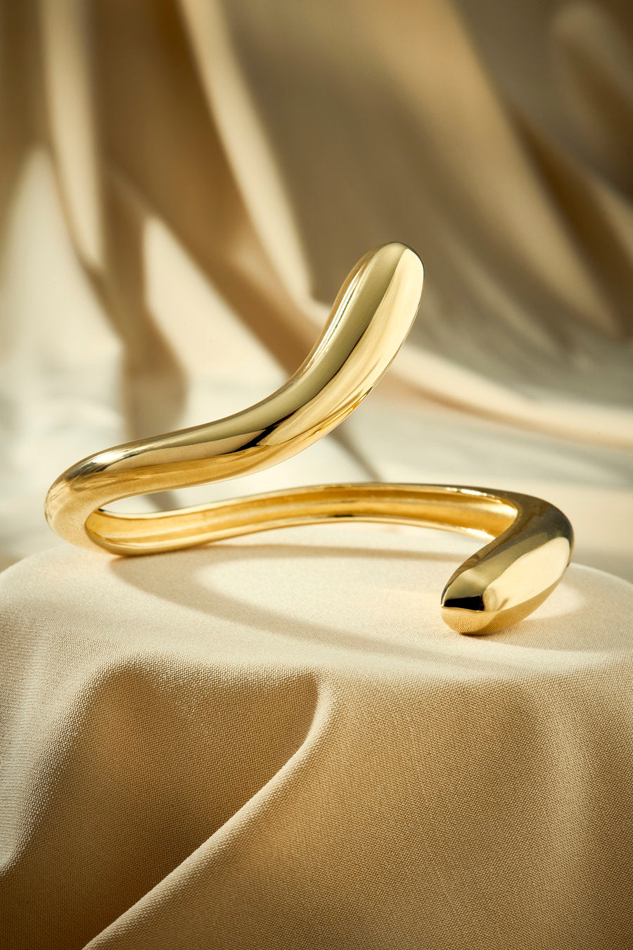 Gold bracelet with curved lines and a contemporary minimalist look.
