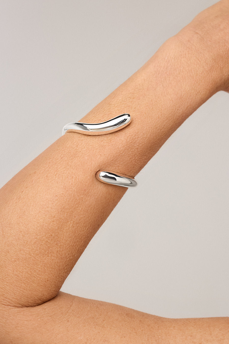 Women's silver bracelet with a fluid, sculptural design and polished finish.
