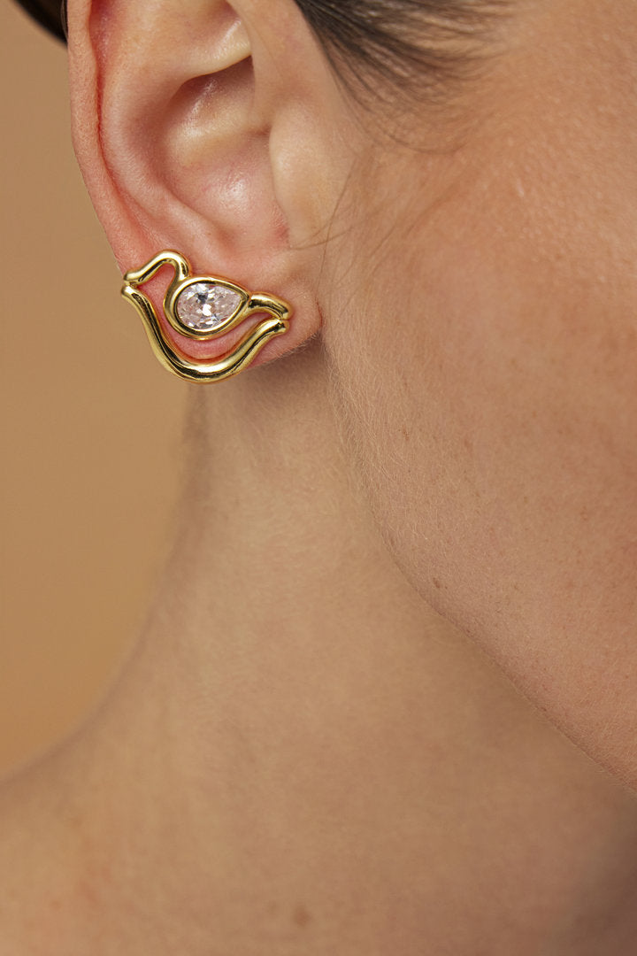 Small gold-tone Audrey earring featuring curved shapes and a prominent faceted crystal.
