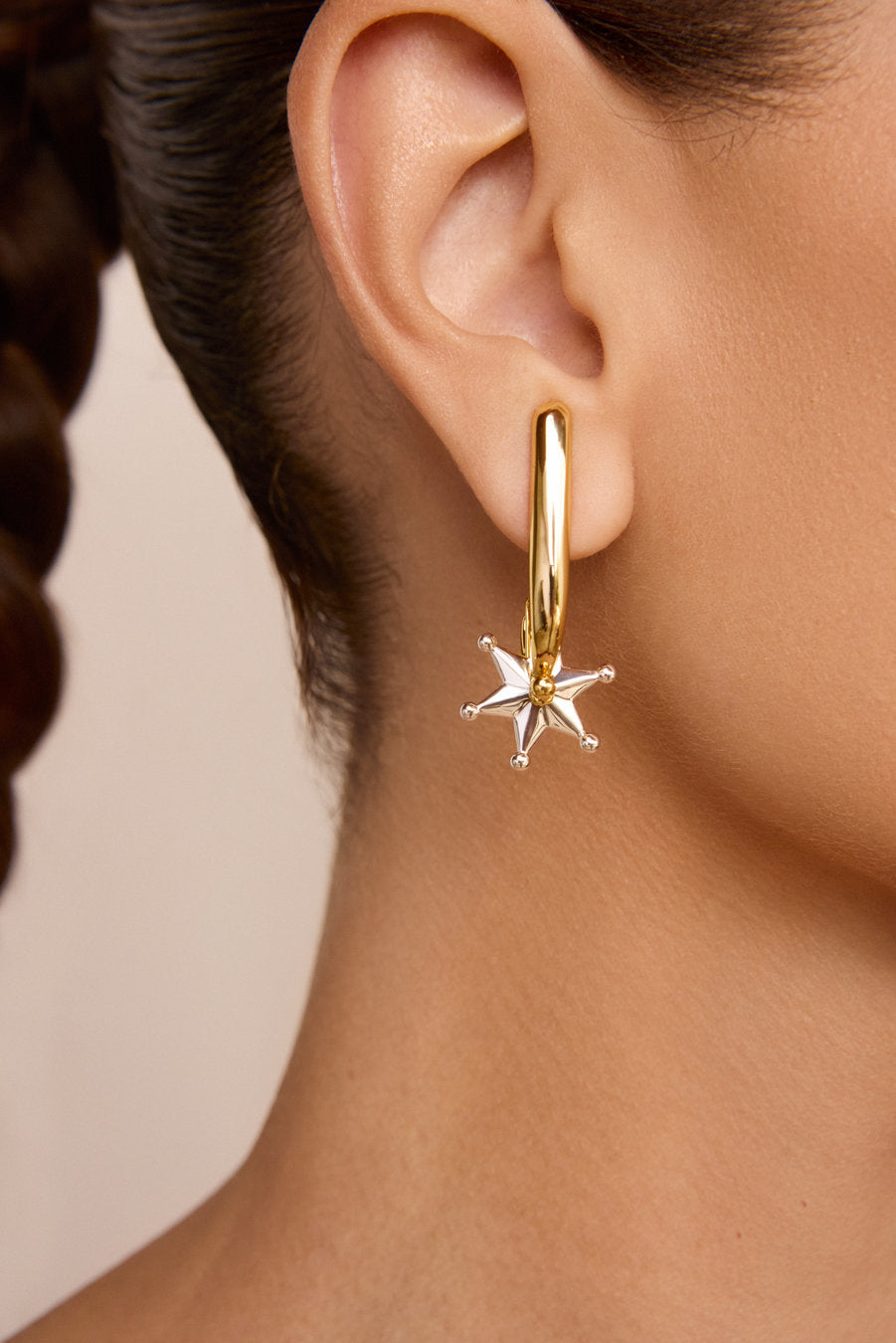 Two-tone gold and silver statement earrings with a sculptural design, polished finish, and silver star, ideal for striking looks.
