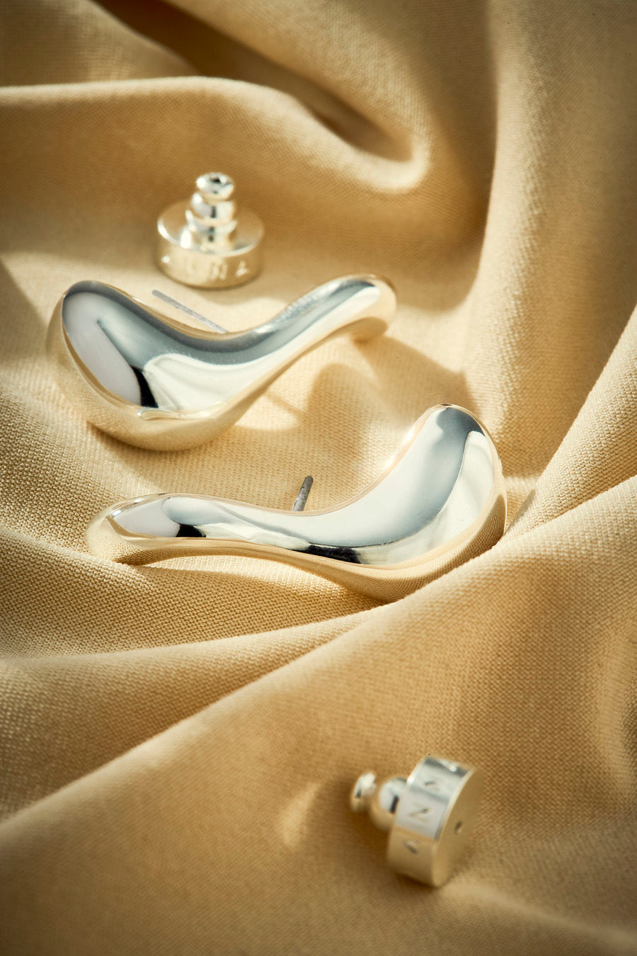 Silver earring with flowing curves and a contemporary elongated shape.
