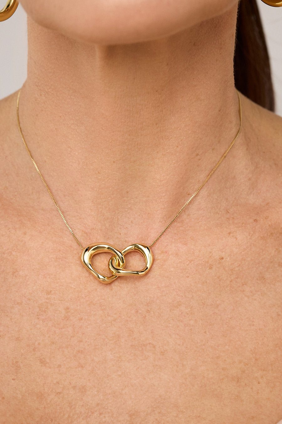 Gold Memory Necklace with intertwined pendants and minimalist design.
