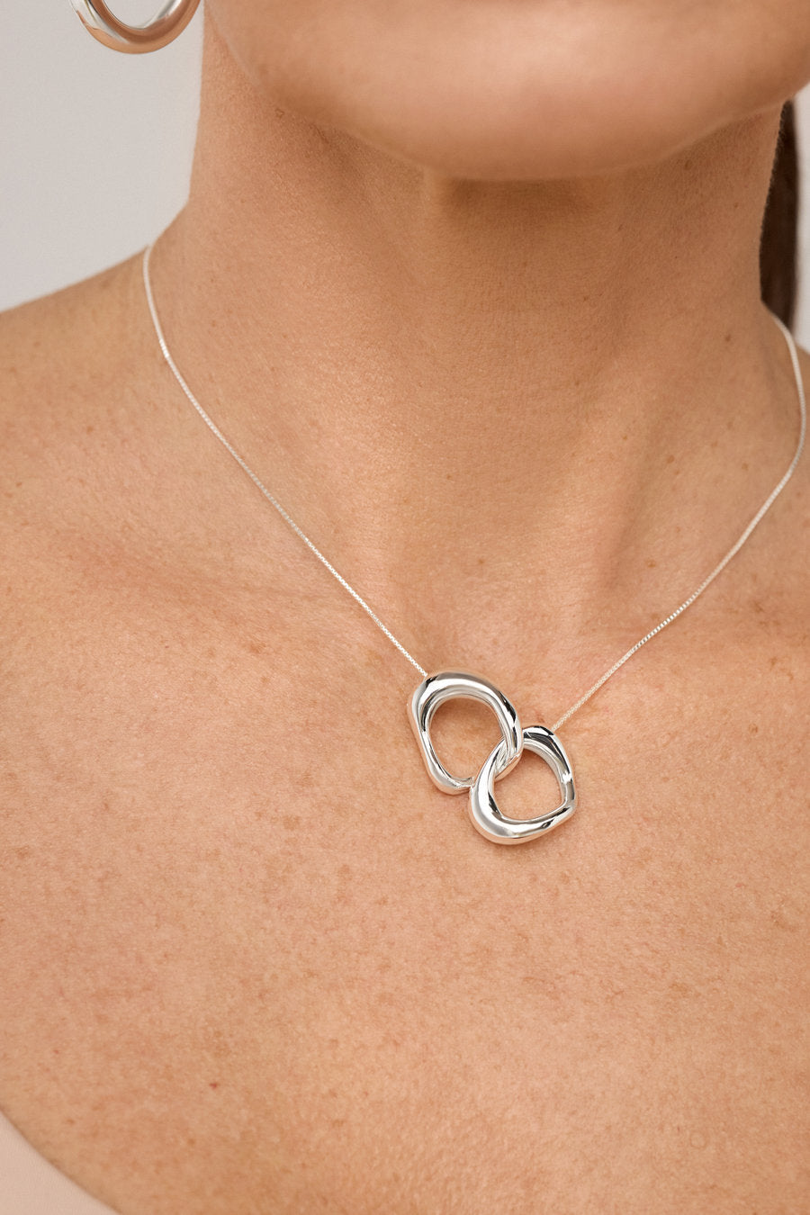 Gold Memory Necklace with intertwined pendants and minimalist design.
