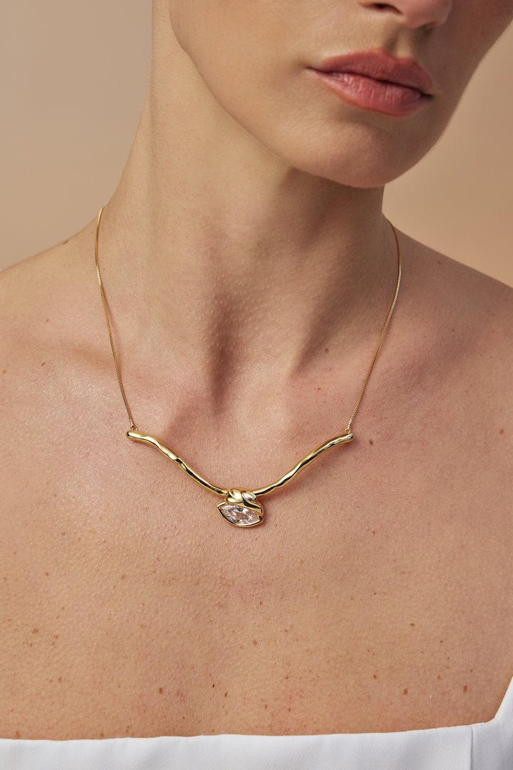 Gold-tone choker with an organic design and a central Austrian crystal.