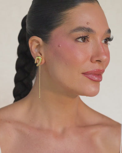 Gold Delicata Small Earring – minimalist design with overlapping curves and a moving chain.