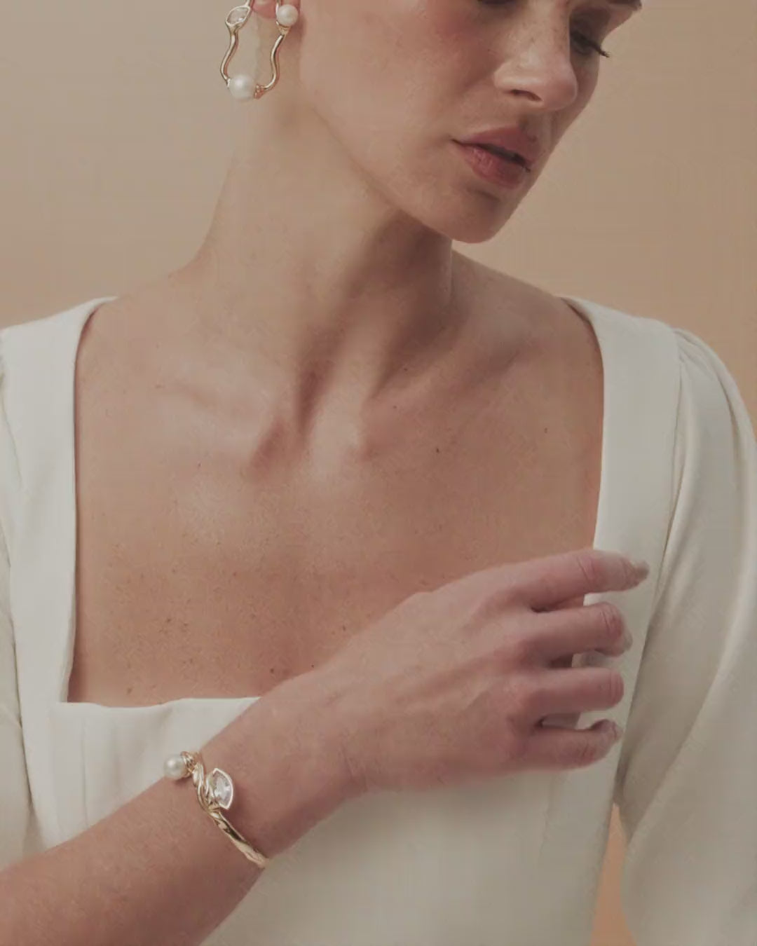 Gabrielle bracelet featuring gold and white gold curves, where pearl and crystal find harmony and light.
