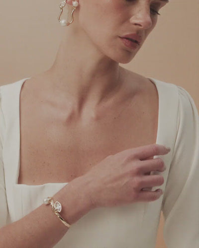 Gabrielle bracelet featuring gold and white gold curves, where pearl and crystal find harmony and light.
