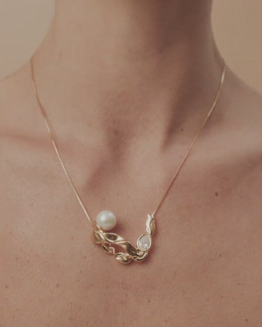Audrey necklace in gold and white gold, featuring pearls, Austrian crystal, and fluid shapes that evoke the charm of classic cinema.