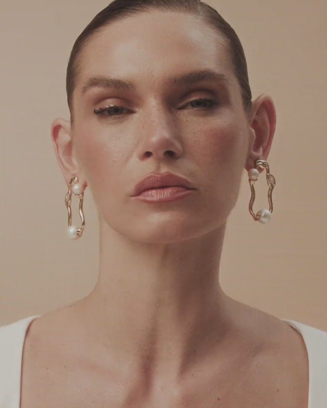 The gold and white gold Gabrielle earring, set with pearls and crystals, traces the serene radiance of a free-spirited elegance in metal.