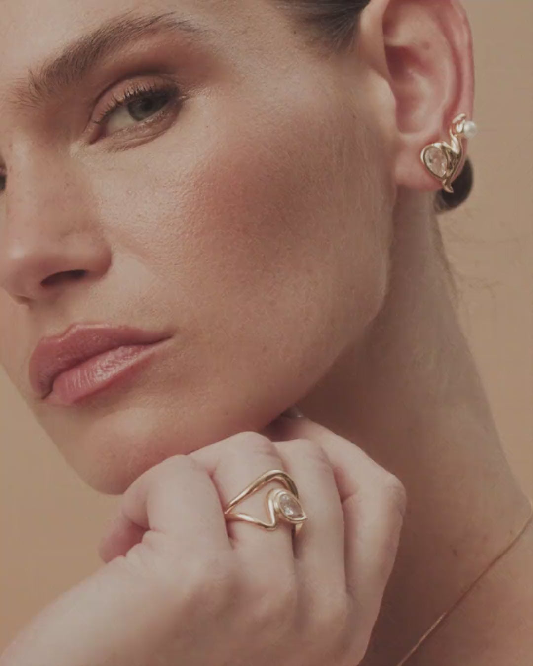 Adjustable Audrey ring in gold and white gold, featuring a central crystal embraced by curves of serene elegance.
