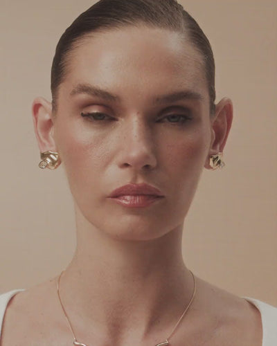 Elsa earring in gold and white gold  a small organic sculpture where the crystal emerges from forms shaped by time.
