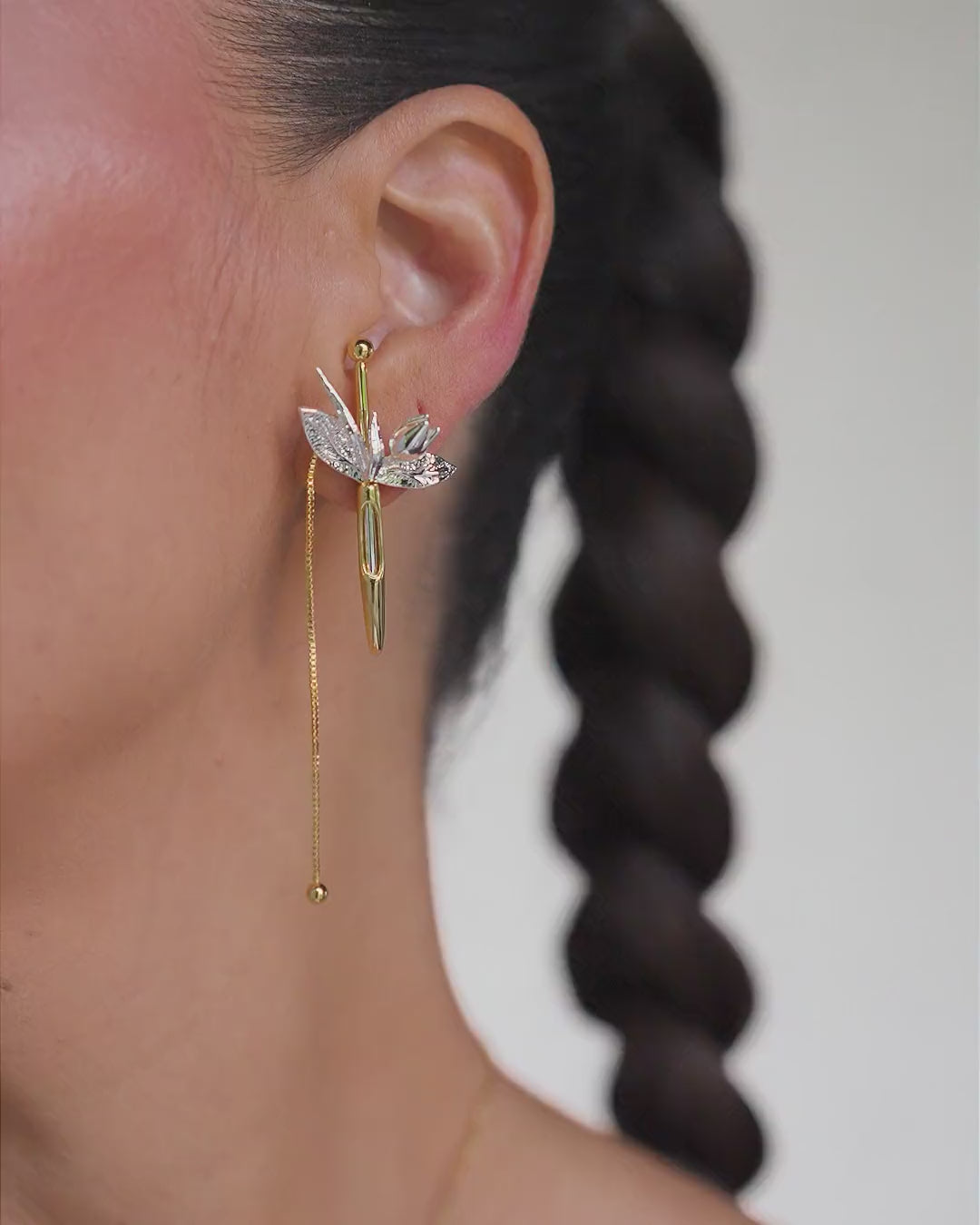 Plenitude gold and silver earring – elongated floral design featuring chains, leaves, and organic shapes.