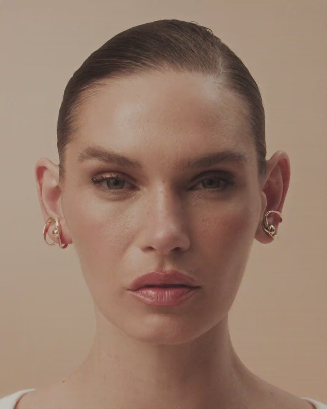 Frida white gold and gold drop earring, featuring organic metal and a long chain that extends the free movement of a brushstroke.
