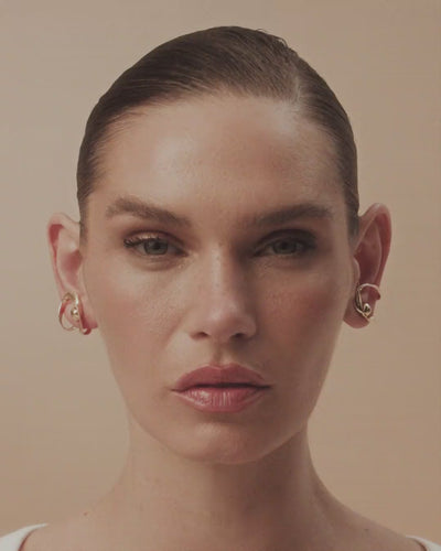 Frida white gold and gold drop earring, featuring organic metal and a long chain that extends the free movement of a brushstroke.
